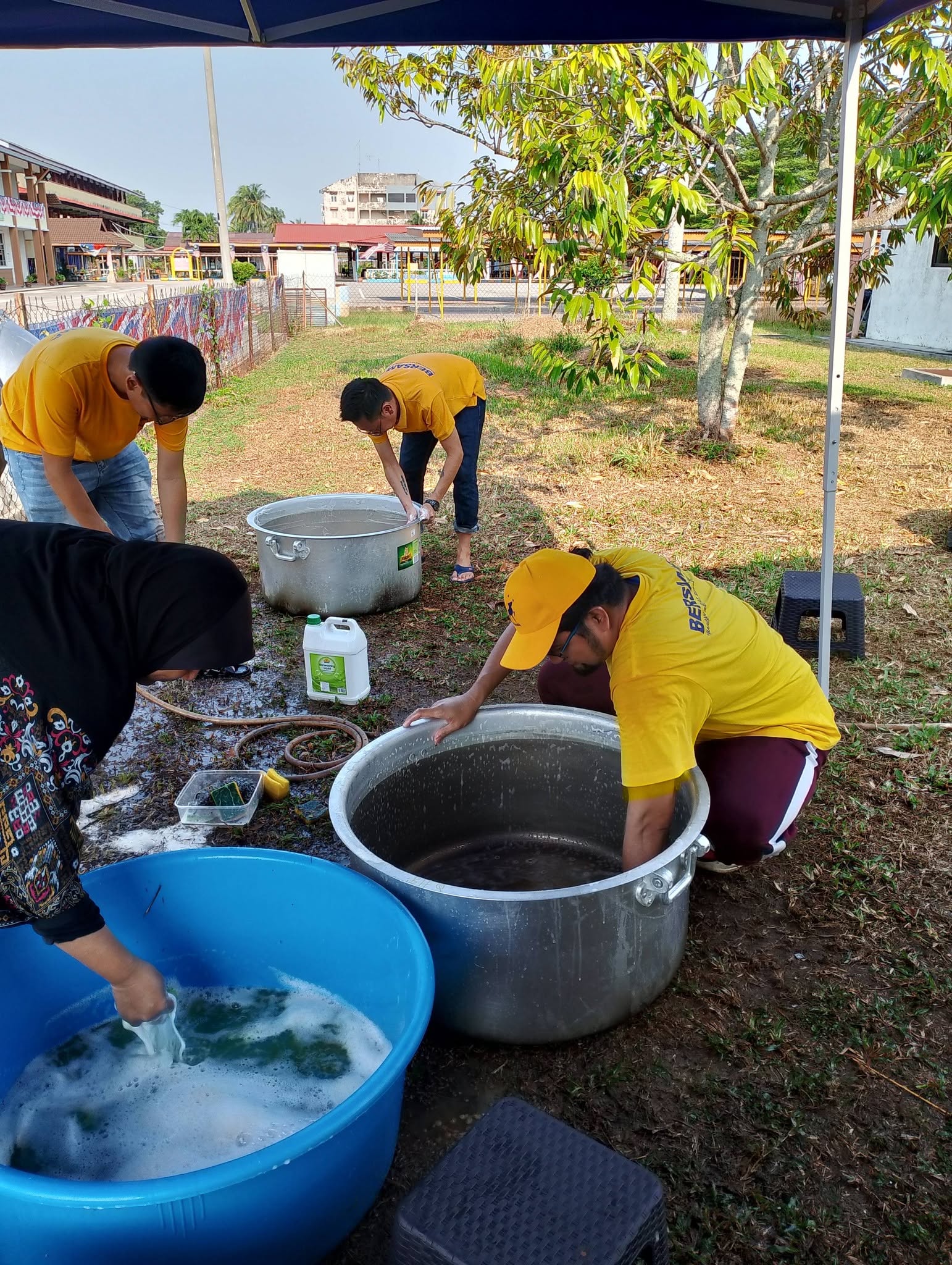 Pasukan bergotong-royong mencuci periuk dan besen yang digunakan untuk kenduri.