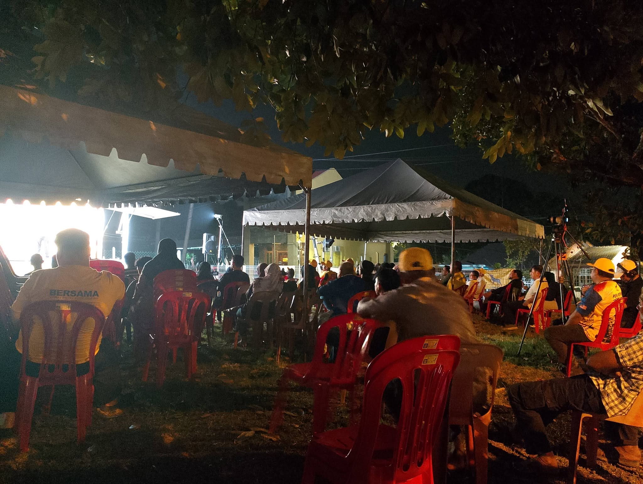 Hadirin duduk di bawah khemah mengikuti ceramah pada waktu malam.